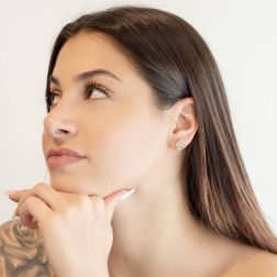 Photo of worn Curved diamond-shaped stud earrings in yellow and white gold