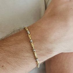 Photo of worn Tubular bracelet with round striped partridge eye in yellow gold alternating with 2 white eyelets