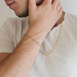 Photo of worn Tubular bracelet with round striped partridge eye in yellow gold alternating with 2 white eyelets