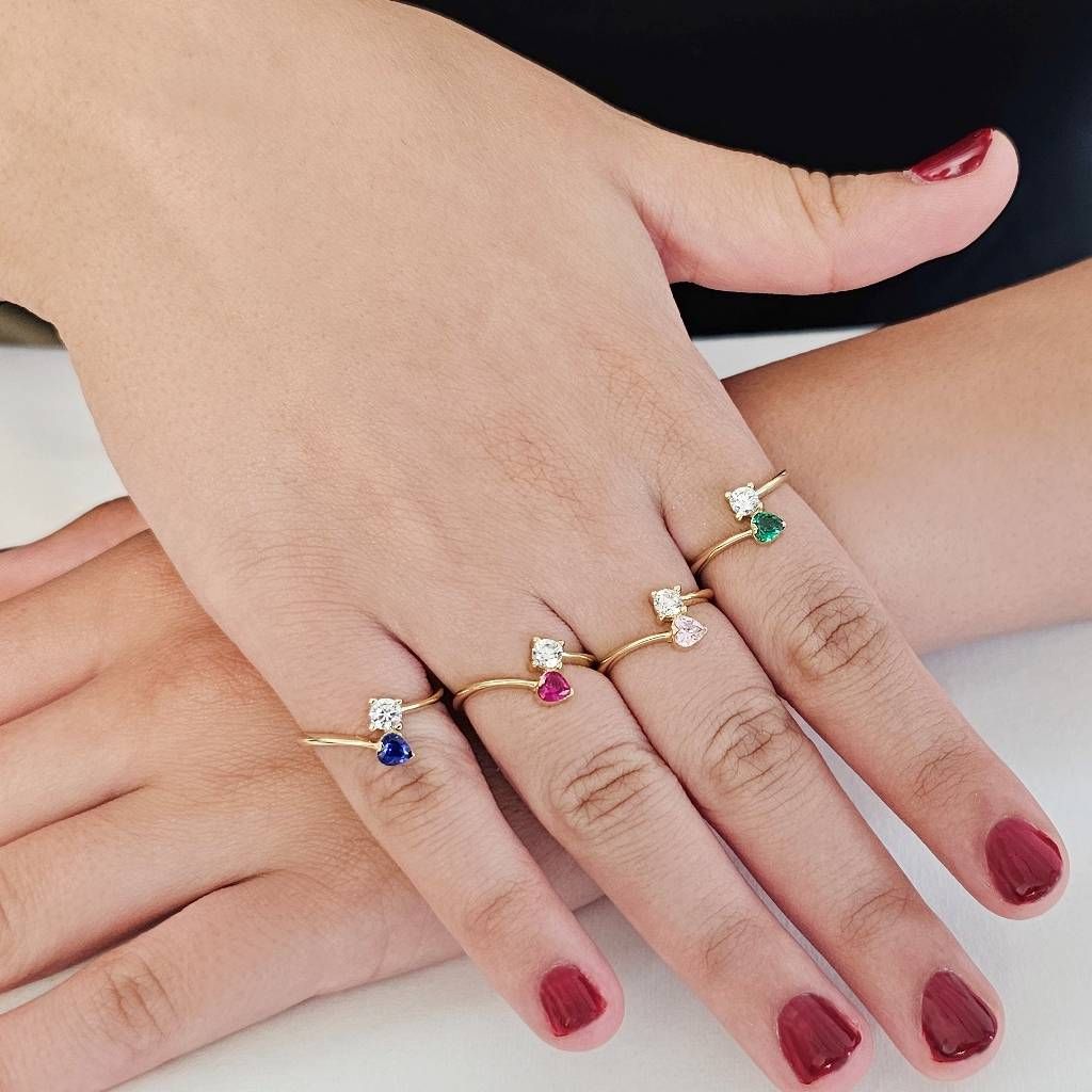 Photo of worn Contrariè ring with 2 zircons, coloured heart, in yellow gold