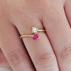 Photo of worn Contrariè ring with 2 zircons, coloured heart, in yellow gold