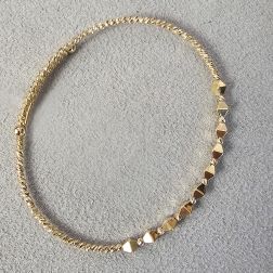 Open bangle bracelet with balls and three-dimensional rhombuses in yellow gold