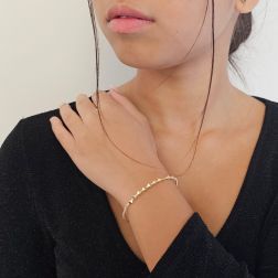 Photo of worn Open bangle bracelet with balls and three-dimensional rhombuses in yellow gold