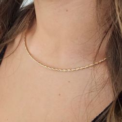 Photo of worn Semirigid flexible intertwined faceted necklace in yellow and white gold