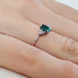 photo of worn 6x4mm Oval Emerald Solitaire Ring with 6 Diamonds in White Gold