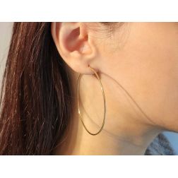 Photo of worn  Round hollow cane 5.4cm x 1.2mm hoops in 18kt yellow gold