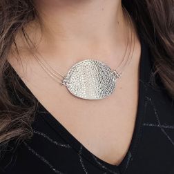 photo of worn Semi-rigid curved medallion necklace in white gold