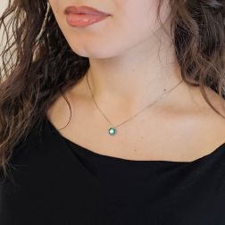 photo of worn Necklace with a 9mm flower pendant with a 0.24ct GIA central diamond and emeralds