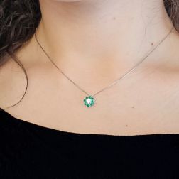 photo of worn Necklace with a 9mm flower pendant with a 0.24ct GIA central diamond and emeralds