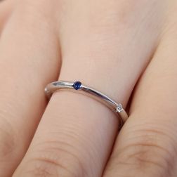 Photo of worn Thin pyramid-shaped ring with alternating diamonds, blue sapphires, rubies and emeralds