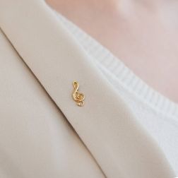 photo of worn Treble clef brooch in yellow gold